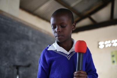 Uganda 5 - Pige taler i mikronfon - står op