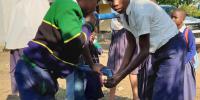 Børn pumper vand fra brønden på skolen i Tanzania