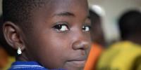 På billedet ses et close-up af en pige fra Uganda. Hun smiler ind i kameraet